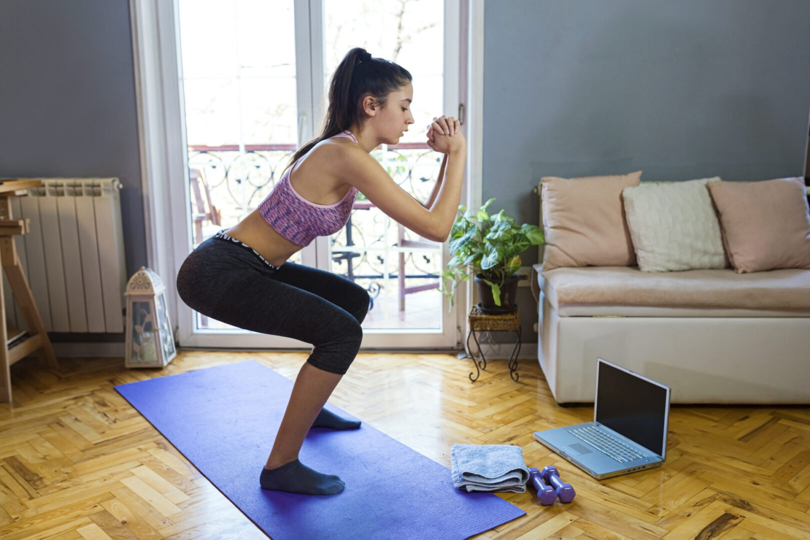 Teenage girl exercising at home.She is using a laptop and smartphone to communicate with friends on social media.
Challenge accepted