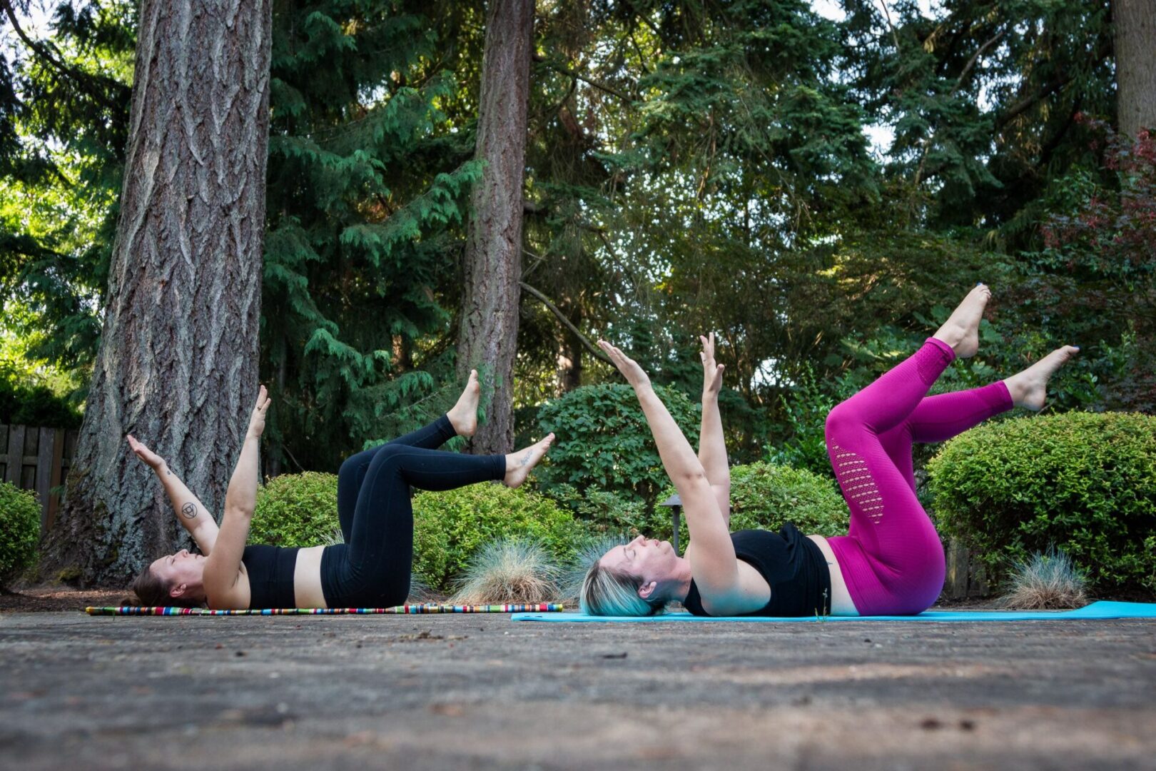 Two women practicing yoga outdoors on mats