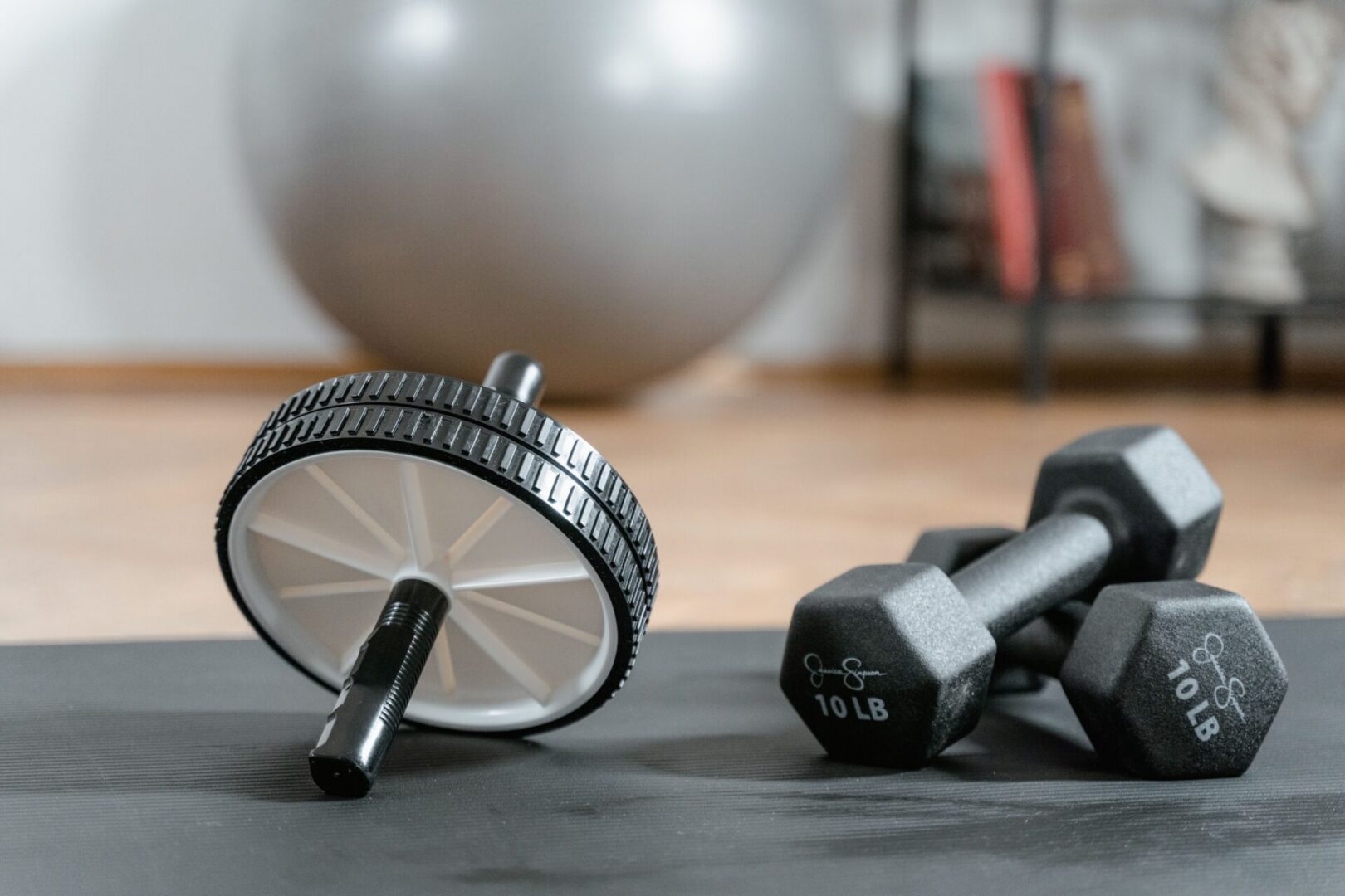 Ab wheel and 10 lb dumbbells on mat