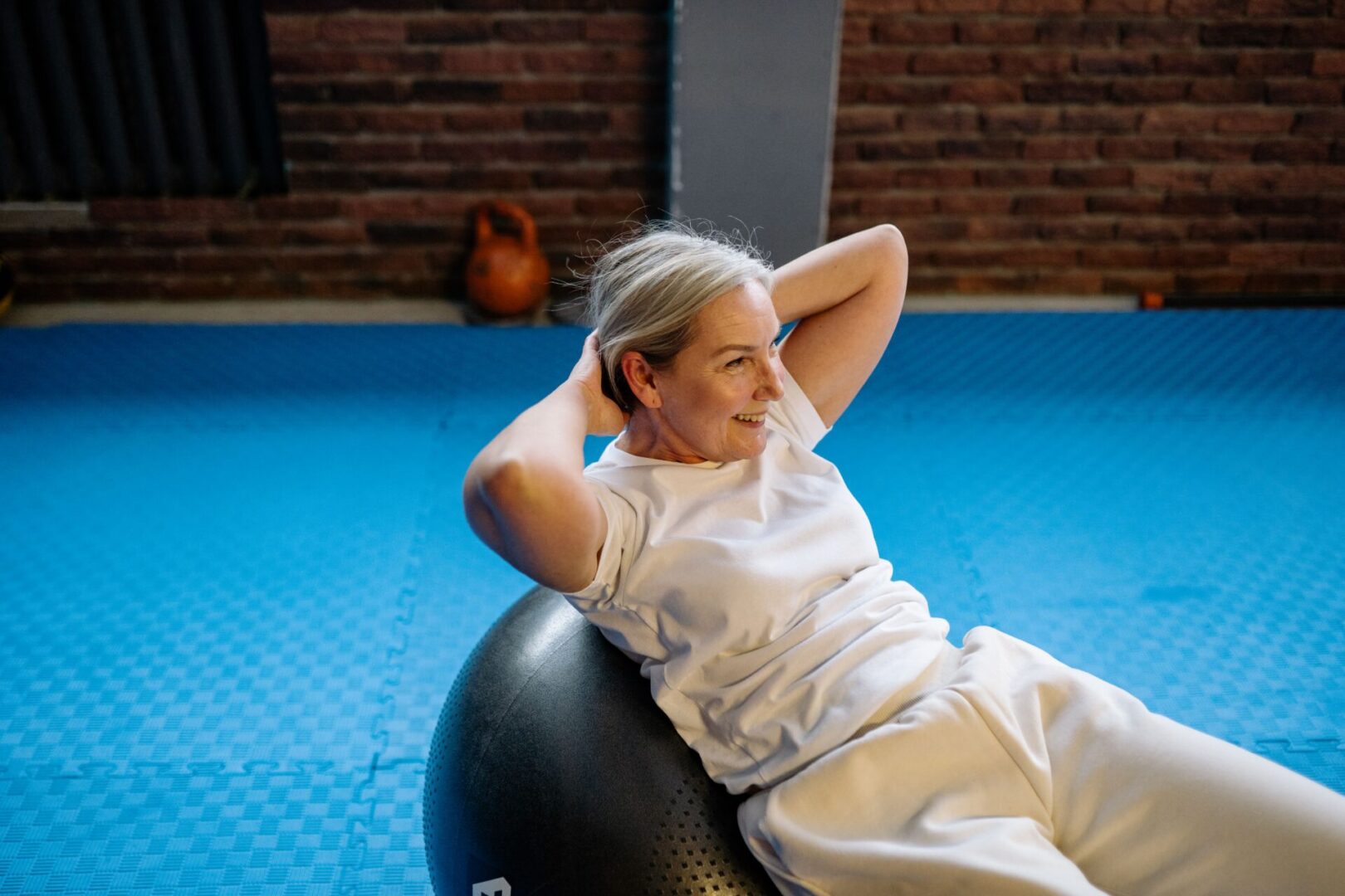 Senior woman doing crunches on exercise ball
