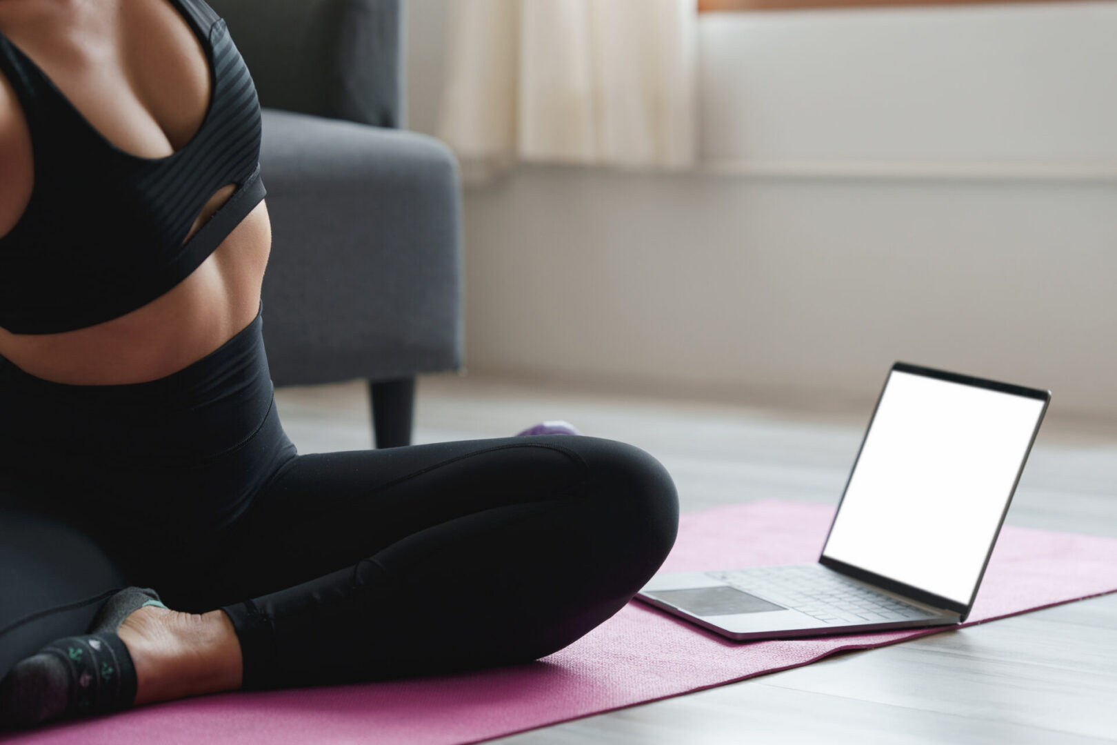 Young woman practicing yoga follow teacher in laptop online class at home. Calmness and relax concept
