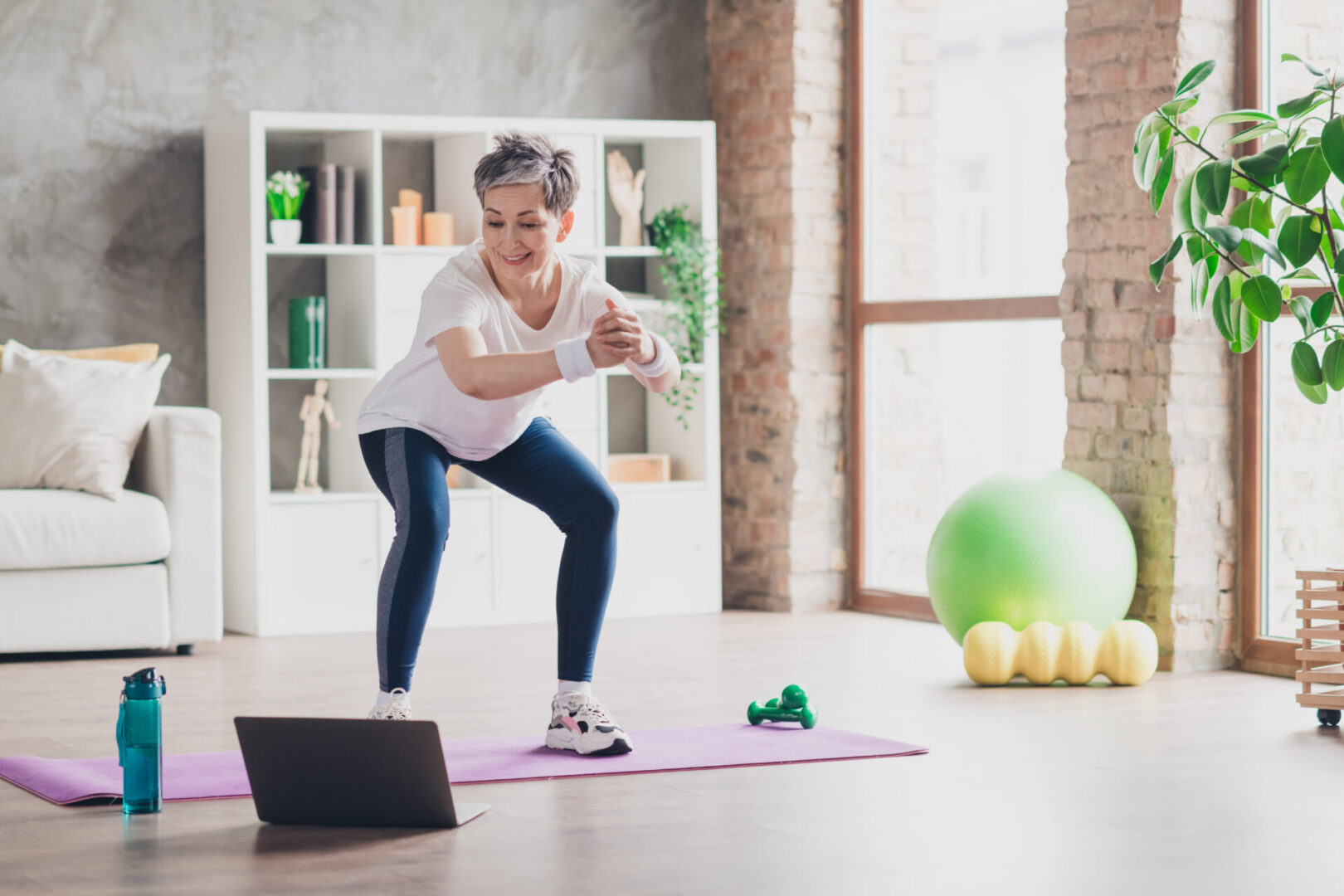 Mature woman doing squats during home workout