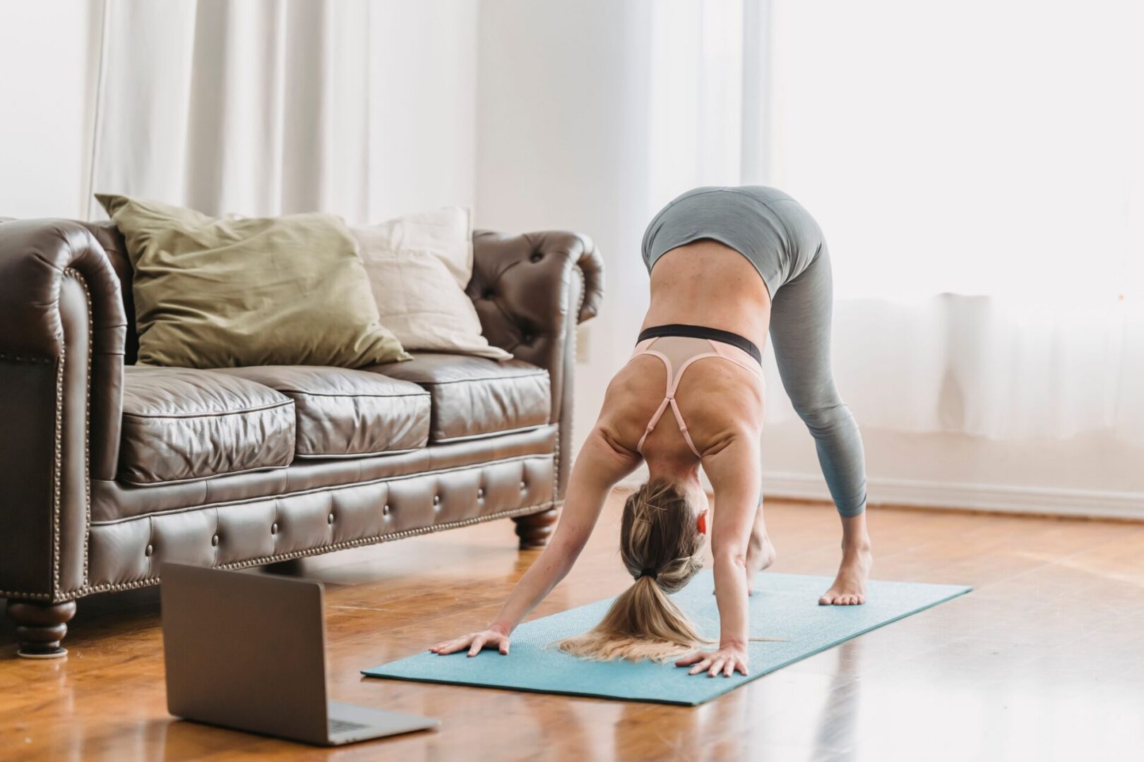 Person doing downward dog yoga pose at home