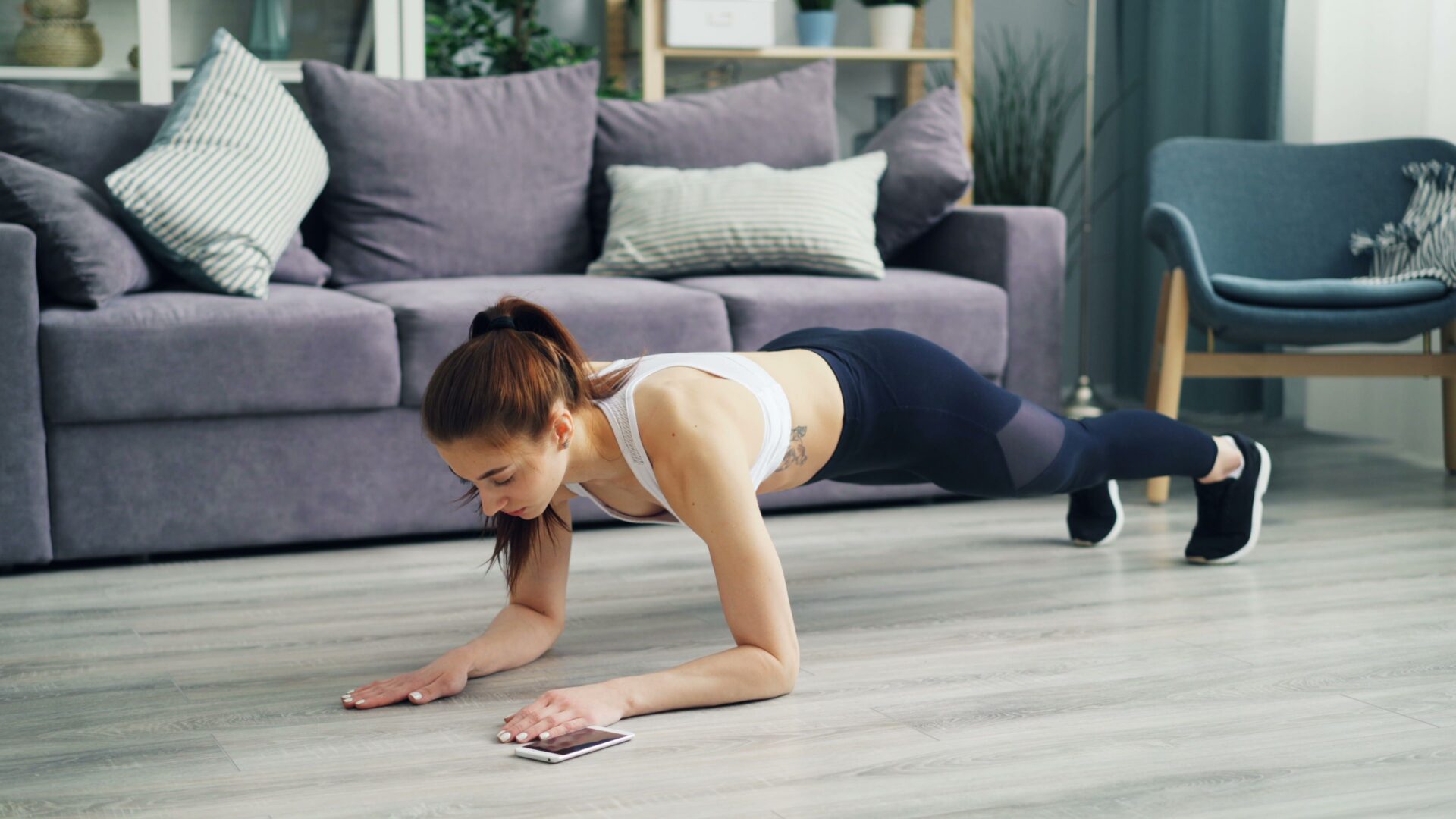 Woman doing plank exercise in living room