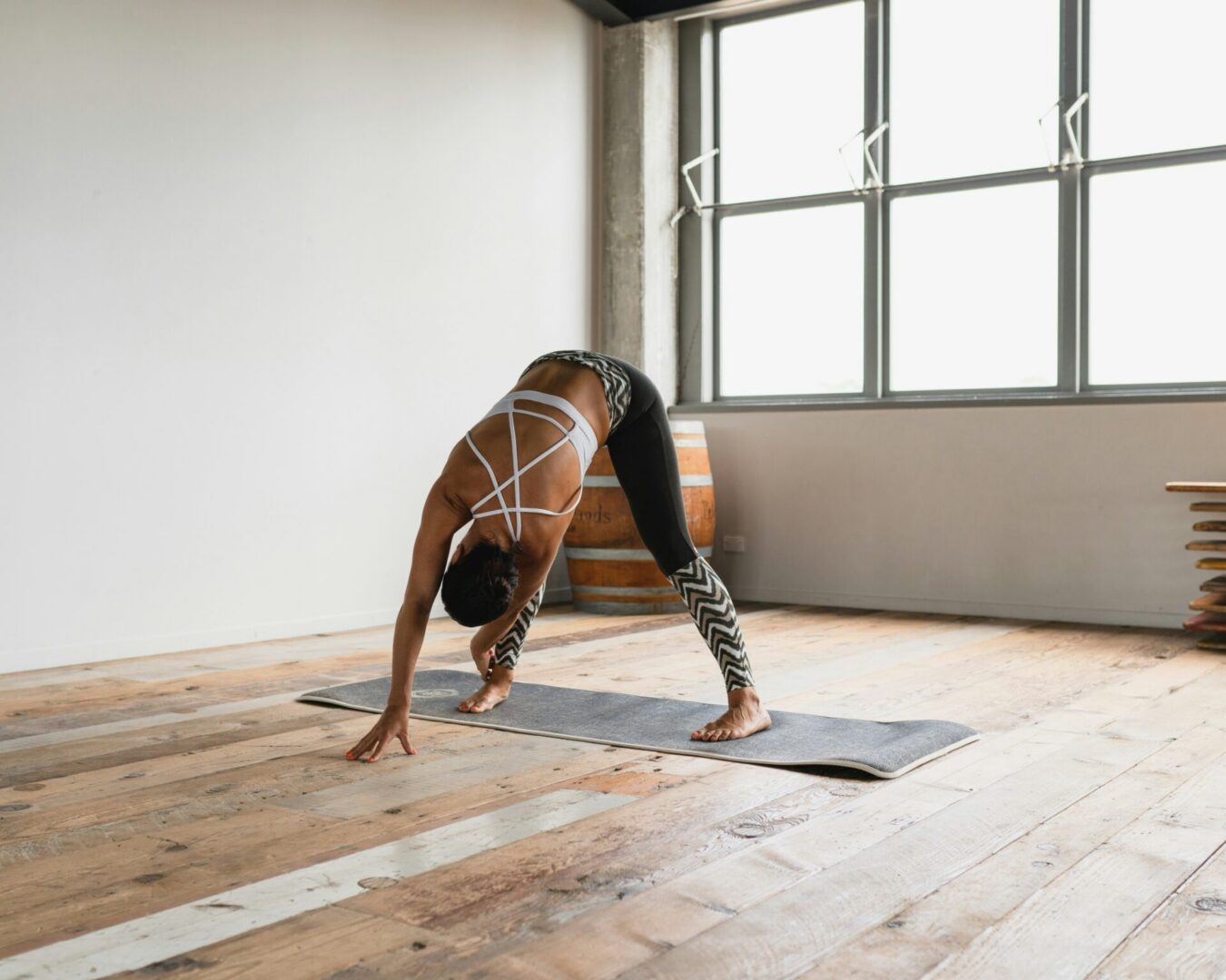 Person doing wide-legged forward bend on yoga mat